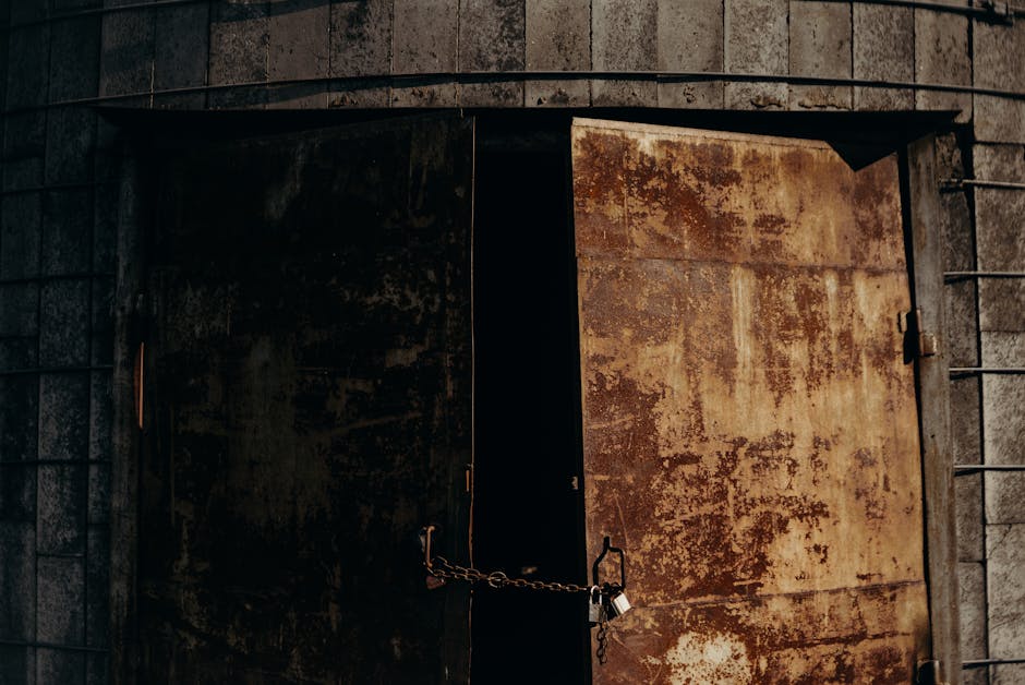 A pair of rusty metal doors chained and padlocked, showcasing urban decay and abandonment.